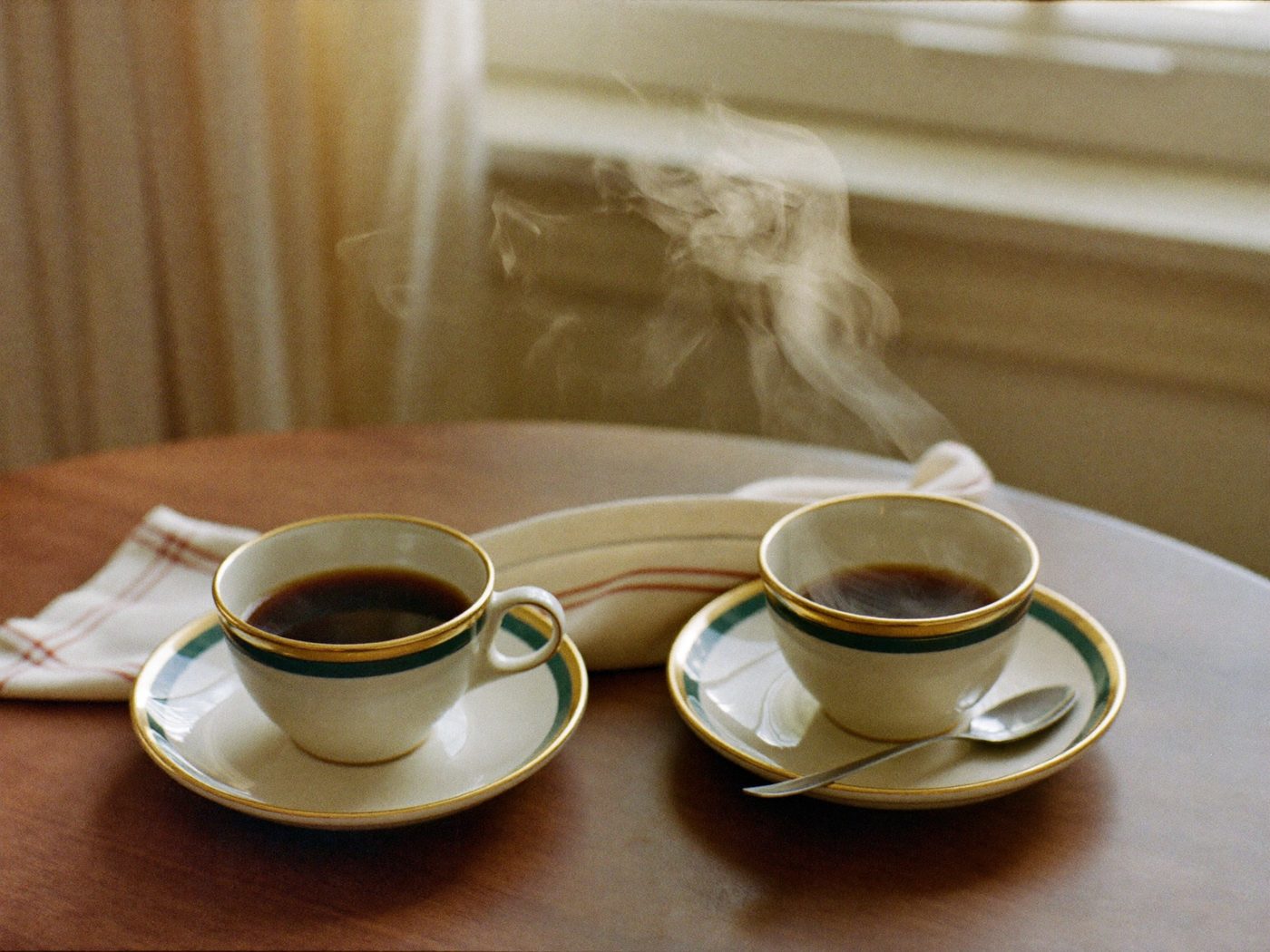 Coffee in a ceramic mug on a sunlit wooden table